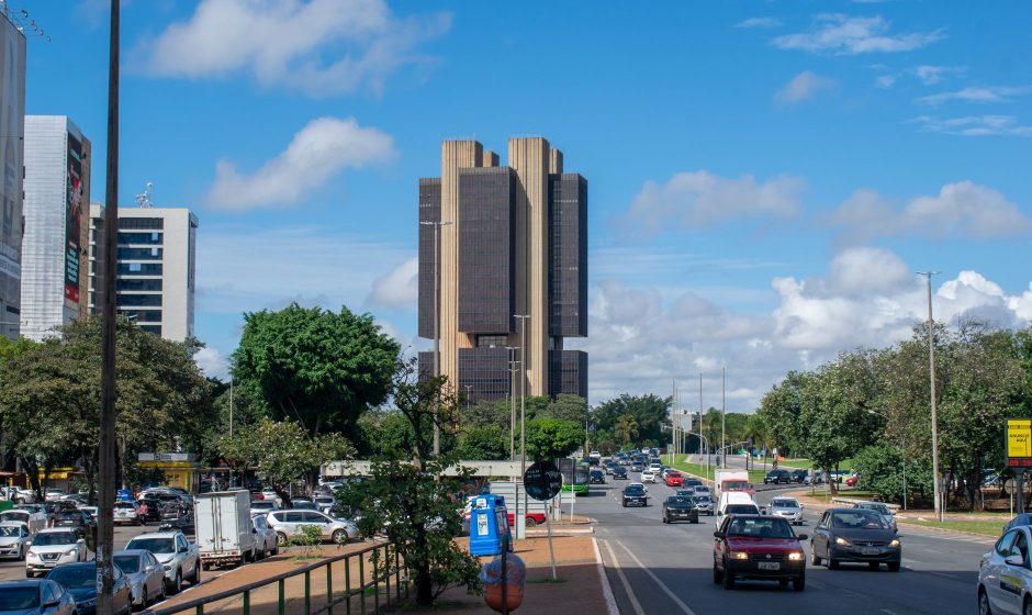 Vista externa do edifício do Banco Central do Brasil em Brasília, sob um céu colorido.