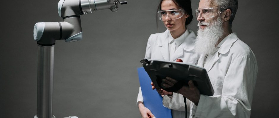Pesquisadores examinam um braço robótico em um laboratório de tecnologia.